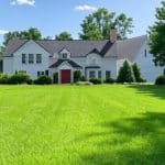 Well-manicured lawn with Ohio home and native foliage highlighting natural lawn care benefits.